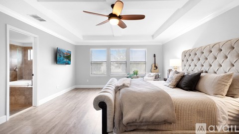 A bedroom with a large bed and a ceiling fan.