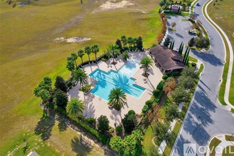 An aerial view of a house with a pool and palm trees.