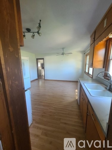 A kitchen with wooden floors and a counter with a sink.