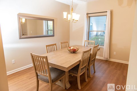 A dining room with a wooden table and chairs.