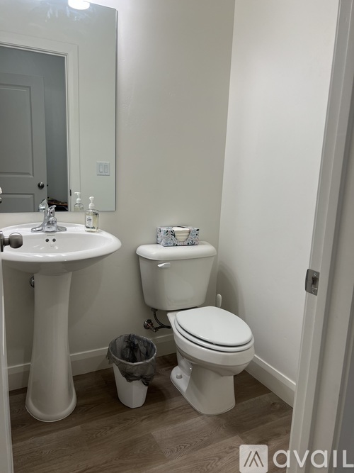 A bathroom with a sink, toilet and a mirror.
