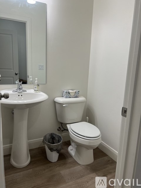A bathroom with a sink, toilet and a mirror.