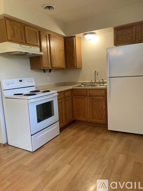 A kitchen with a white stove and a white refrigerator.