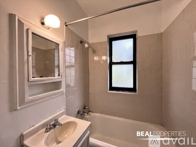 A bathroom with a white sink, a window, and a bathtub.