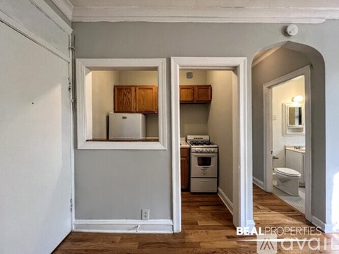 A kitchen with a refrigerator, oven, and cabinets is shown in this image.