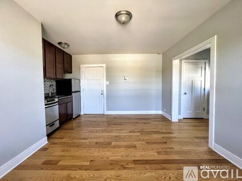 A kitchen with wooden floors and white walls.