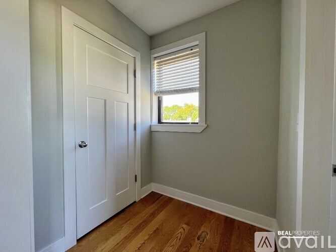 A room with a white door and a window with blinds.