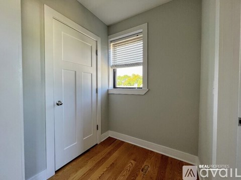 A room with a white door and a window with blinds.