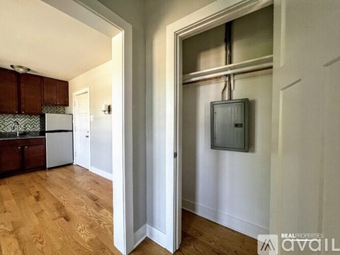 A kitchen with wooden floors and a white refrigerator.