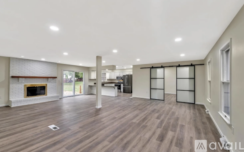 A spacious living room with a fireplace and sliding glass doors.