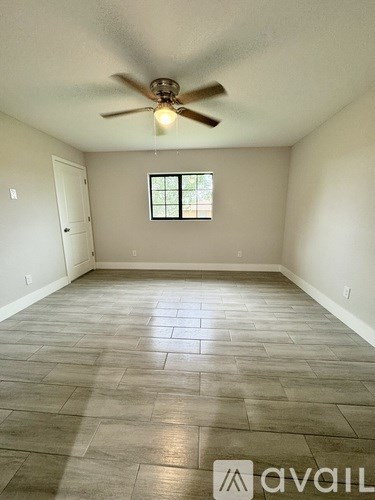 A room with a ceiling fan and a window.