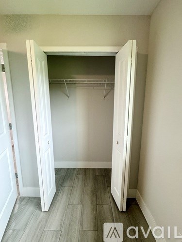 A white closet with a grey floor and a grey wall.