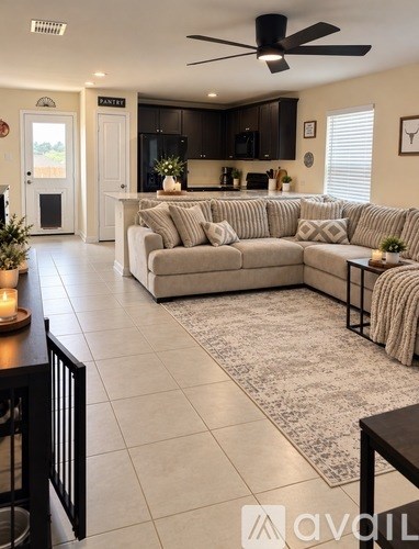 A living room with a couch, a coffee table, and a ceiling fan.