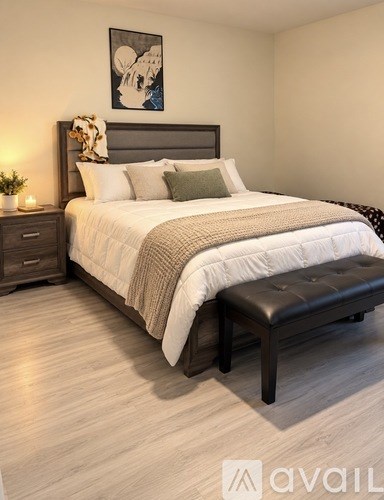 A bedroom with a large bed and a bench.