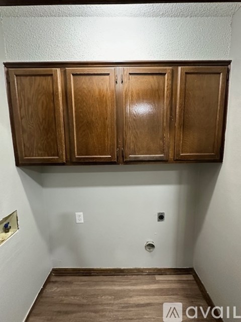 A wall with a shelf and three cabinets above it.