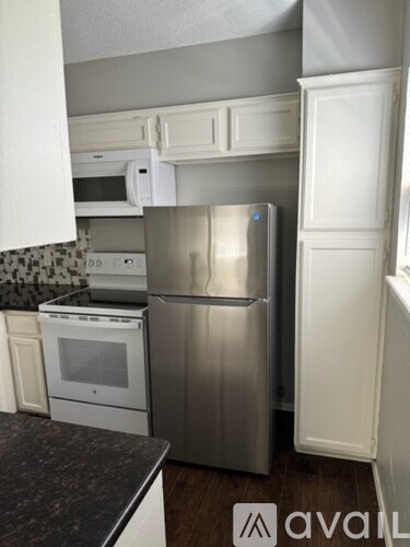 A kitchen with a stainless steel refrigerator and a white oven.
