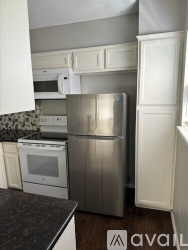 A kitchen with a stainless steel refrigerator and a white oven.