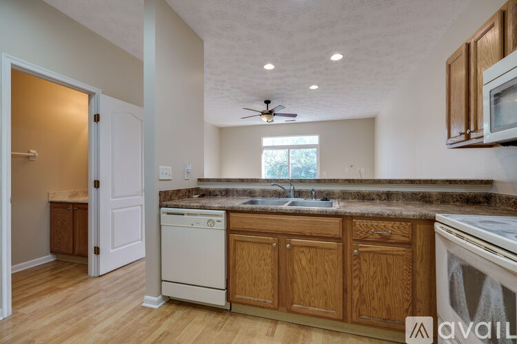 A kitchen with wooden cabinets and a white dishwasher.
