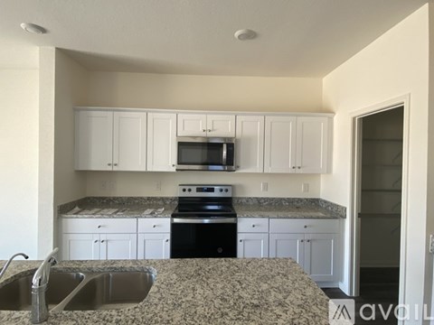 A kitchen with granite countertops and white cabinets.