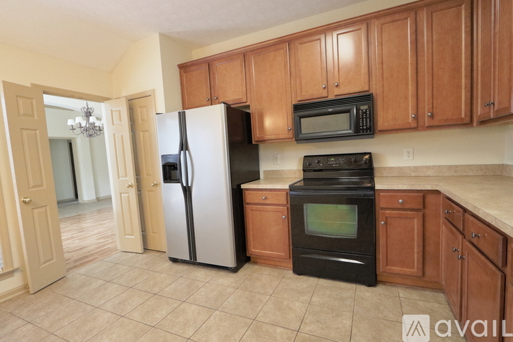 A kitchen with a black oven and a white fridge.