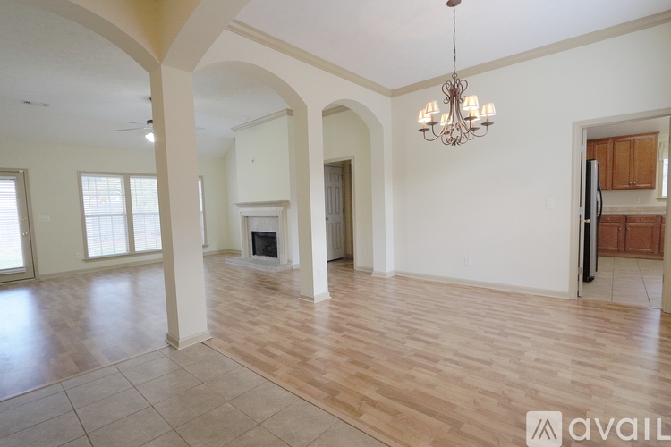 A spacious living room with a chandelier and a fireplace.