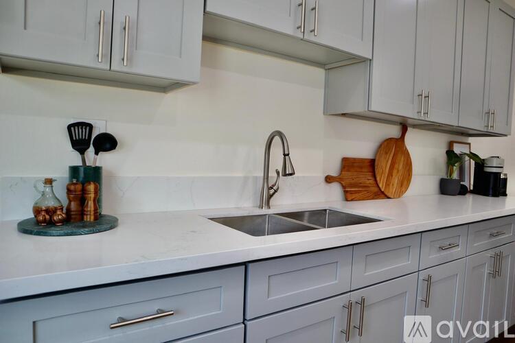 A kitchen with a white countertop and grey cabinets.