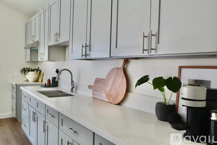 A kitchen with white cabinets and a marble countertop.