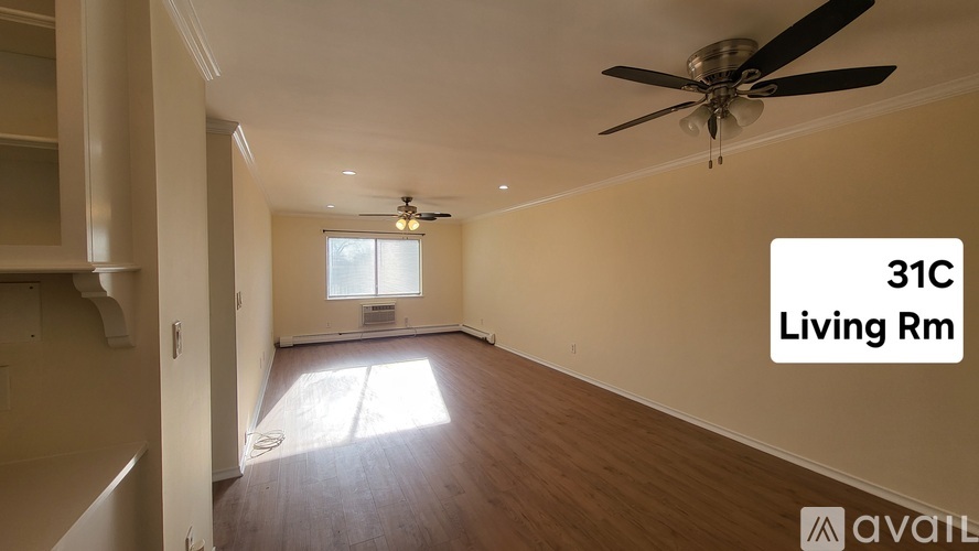 A living room with a ceiling fan and a window.