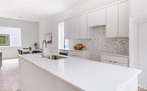 A kitchen with white cabinets and a white countertop.