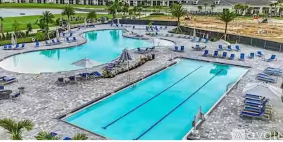 A large outdoor swimming pool with multiple lanes and sun loungers.