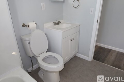 A white toilet and sink in a bathroom.