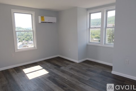 A room with a window and a wall-mounted air conditioner unit.