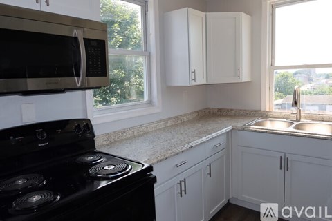 A kitchen with a black stove and white cabinets.