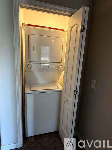 A small white refrigerator is built into a wall.
