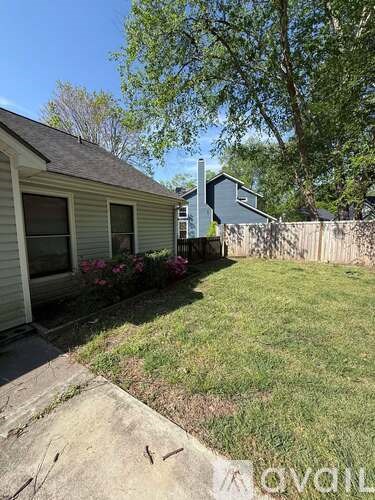 A backyard with a fence and a house.
