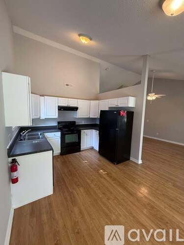 A kitchen with black appliances and white cabinets.