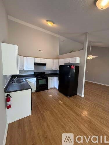 A kitchen with black appliances and white cabinets.