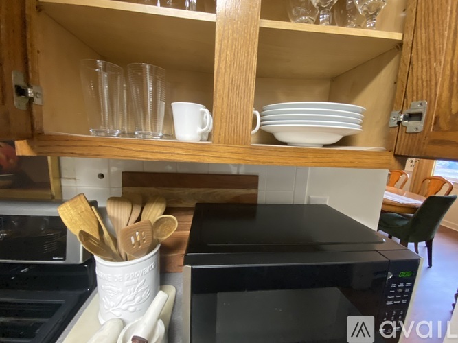 A kitchen with a microwave, oven, and wooden cabinets.