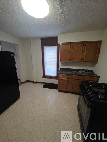 A kitchen with black appliances and wooden cabinets.