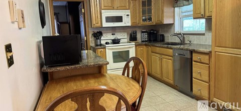 A kitchen with wooden cabinets and a black microwave.