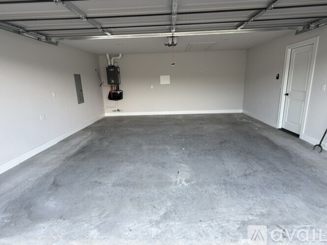A spacious garage with a concrete floor and white walls.