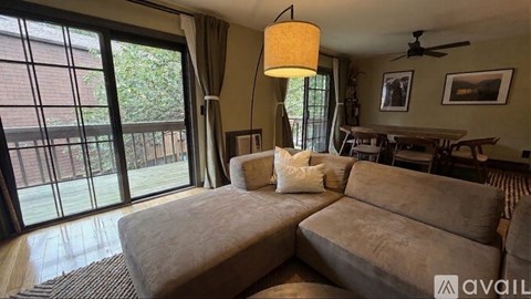 A living room with a large couch and a fan on the ceiling.