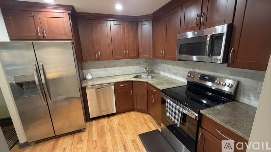 A kitchen with wooden cabinets and a stainless steel refrigerator.