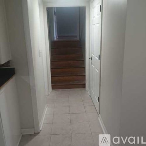 A hallway with a closed door and a staircase.