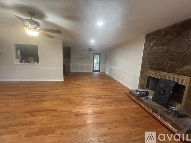 A living room with wood flooring and a fireplace.