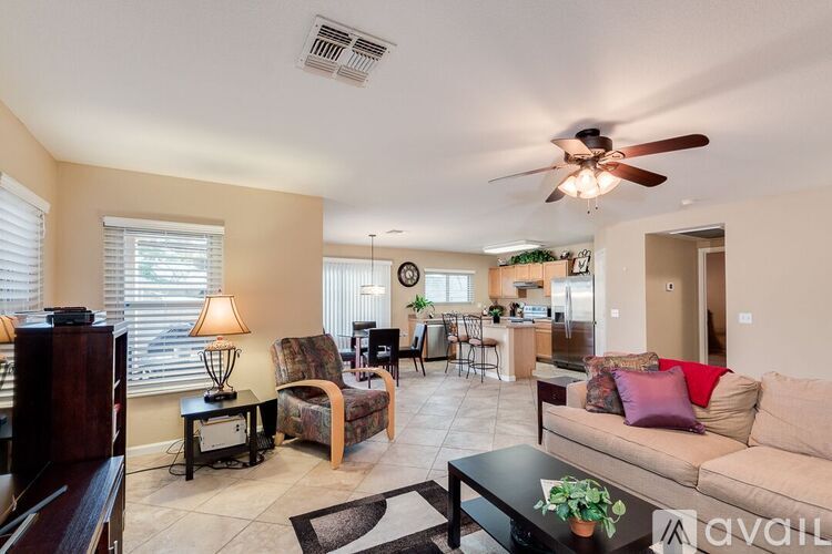 A living room with a couch, chairs, and a dining table.
