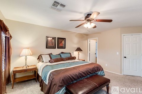 A bedroom with a large bed and a ceiling fan.