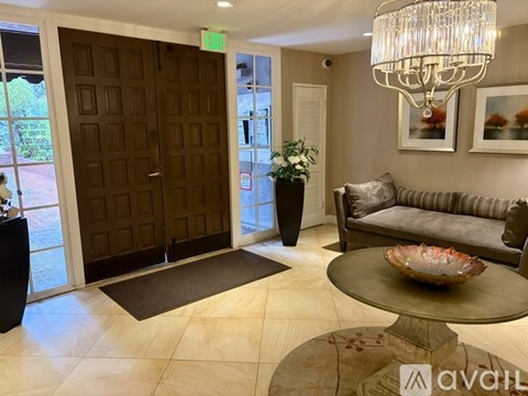 A living room with a couch, coffee table, and a chandelier.