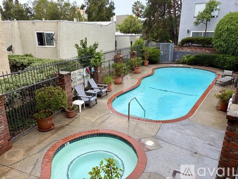 A backyard with a small pool and a hot tub.