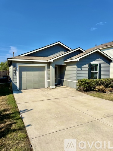 A house with a garage and a driveway in front.